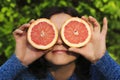 Funny playful woman holding halves of citrus fruits Royalty Free Stock Photo