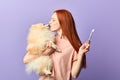 Funny pleasant ginger girl kissing with her adorable dog