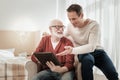 Funny pleasant men sitting and overlooking the tablet.