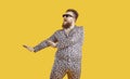 Funny plus size man in sunglasses and leopard PJs dancing and singing in fashion studio