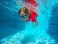 Funny portrait of baby girl swimming and diving in blue pool Royalty Free Stock Photo