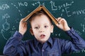 Funny portrait clever pupil boy on school board background