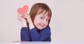 Funny portrait of cute little child girl with red heart as symbol of love and amorousness Royalty Free Stock Photo