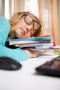 Funny portrait of disheveled young woman sleeping on books