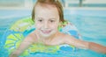 Funny portrait of happy cute little child girl playing with colorful ring in swimming pool Royalty Free Stock Photo