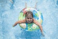 Funny portrait of happy cute little child girl playing with colorful ring in swimming pool. Kids learn to swim Royalty Free Stock Photo