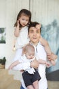 Portrait of a happy young father with a baby son and little daughter at home Royalty Free Stock Photo