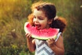 Funny portrait of an incredibly beautiful curly haired little girl eating watermelon, healthy fruit snack, adorable toddler child Royalty Free Stock Photo