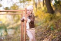 Funny portrait of a little girl. Little girl in a pink hat on a walk in the fall. Child girl in a jacket happily runs and collects