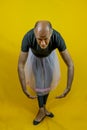 Funny portrait of male ballet dancer. A mature ballet dancer dressed in tutu dancing clumsily