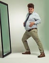 Funny, portrait and man happy with mirror, plus size and overweight with hand on stomach or abdomen. Confident, male Royalty Free Stock Photo