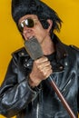 Funny portrait of mature rocker. An old singer dressed in rockabilly style in action Royalty Free Stock Photo