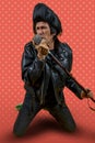 Funny portrait of mature rocker. An old singer dressed in rockabilly style in action Royalty Free Stock Photo