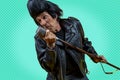 Funny portrait of mature rocker. An old singer dressed in rockabilly style in action Royalty Free Stock Photo