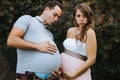 Funny portrait of pregnant wife and pregnant husband