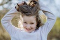 Funny portrait of pretty child girl standing in summer park looking in camera smiling happily. Royalty Free Stock Photo