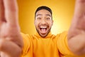 Funny, portrait and selfie of excited man in studio isolated on a yellow background. Face, smile and Asian person taking Royalty Free Stock Photo