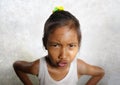 Funny portrait of sweet angry and mad 8 or 9 years old child looking upset to the camera feeling and unhappy isolated on