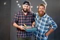 Funny portrait of two cheerful craftsmen with painters workers tools. home renovation and wall painting Royalty Free Stock Photo