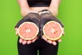 Funny portrait of young brunette fitness woman holding fresh pink grapefruit. Healthy eating lifestyle and weight loss concept. Royalty Free Stock Photo