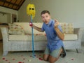 Funny portrait of young weird crazy and happy man holding mop with sunglasses as if it was his fiance kneeling and proposing marri Royalty Free Stock Photo