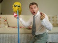 Funny portrait of young weird crazy and happy man holding mop with sunglasses as if it was his fiance kneeling and proposing marri Royalty Free Stock Photo