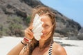 Funny portrait of young woman with sea shell