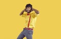 Funny positive arab guy having fun, happy and dancing isolated on orange background.