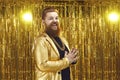 Funny positive overweight man hipster in golden costume and chain standing with palms crossed