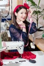 Funny pretty young pinup woman with sewing machine and measuring tape Royalty Free Stock Photo