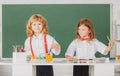 Funny pupils draws in classroom on school blackboard background. School friends kids boy and girl painting together in Royalty Free Stock Photo