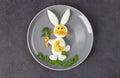 Funny rabbit made from boiled eggs, peeled carrots and arugula on gray plate. Creative food idea for kids, Top view