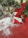 a funny rag Santa Claus with an oversized red hat pulled down to his nose on a red carpet with artificial snow and a Christmas Royalty Free Stock Photo