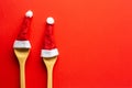 Funny red christmas background with wooden spoon and two red santa hats. Royalty Free Stock Photo