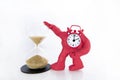 Funny red Clock with hourglass on white table. Daylight Saving Time Concept Royalty Free Stock Photo