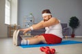 Funny red fat man doing exercises on the floor while standing at home. Royalty Free Stock Photo