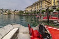 Funny red racing car shaped boats on Lake Lugano, Switzerland, with the city in the background Royalty Free Stock Photo