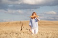 Funny redhead woman with french baguette in ripe wheat field