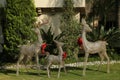 Funny reindeers with red bows near house. Festive outdoor Christmas decoration