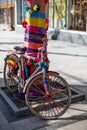 Funny retro colorful bicycle parked at the bright knitted tree