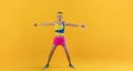 Funny retro sport nerd lifting weights on yellow background. Royalty Free Stock Photo