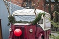 Funny retro wagon dressed up as Rudolph the reindeer. Reindeer antlers, clown nose and Christmas garlands on old van.