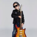 Funny rock child with guitar.fashionable little boy in sunglasses Royalty Free Stock Photo