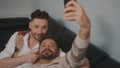 Funny romantic male gay couple using smartphone for video call.