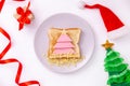 Funny sandwich with edible Christmas tree made from toast bread, sausage and cheese. Breakfast idea for kids. New Year