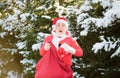 Funny Santa with Gift on Christmas Eve outside. Postcard, greeting card.