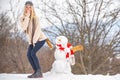 Funny Santa girl posing on winter weather. Joyful Funny young woman Having Fun with snowman in Winter Park. Happy Winter Royalty Free Stock Photo