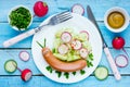 Funny sausage snail with vegetable salad, food art idea