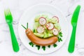 Funny sausage snail with vegetable salad, food art idea