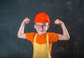 Funny school boy in red safety helmet and shirt and yellow suit pretend to be engineering. Education for children Royalty Free Stock Photo